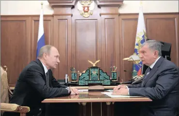  ?? PHOTO: EPA ?? Russia’s President Vladimir Putin, left, listens to Rosneft CEO Igor Sechin reporting results of selling 19.5 percent of the company’s stake to Glencore and a Qatari fund consortium.