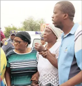  ?? REACTION: ?? Family members of Elizabeth Dube outside her home where the gruesome discovery was made.