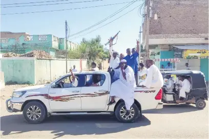  ?? Pictures: AFP ?? UP IN ARMS. Armed Sudanese civilians wave weapons and chant slogans as they drive through the streets of Gedaref city in eastern Sudan on New Year’s Day to express their support for the Army.