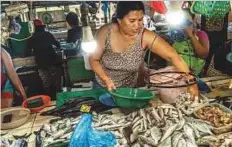  ?? New York Times News Service ?? A woman works at a fish market in Bohol. Experts say that there is a lack of alarm over the collapse of the Philippine fisheries.