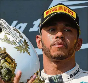  ?? — AP ?? Proud winner: lewis Hamilton celebrates with the trophy on the podium after winning the Hungarian Grand Prix in Budapest yesterday.