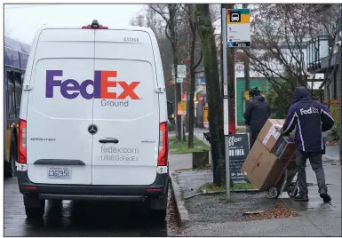  ?? (AP/Ted S. Warren) ?? A FedEx driver works earlier this week in Seattle. Store are warning online shoppers that if holiday purchases aren’t made soon, they may not be delivered in time for Christmas.