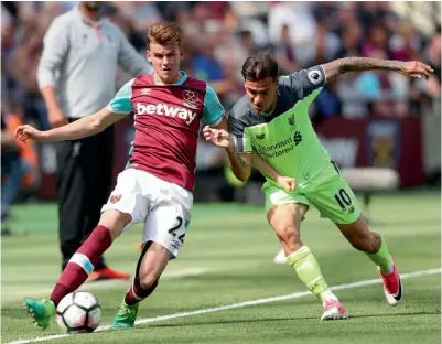  ?? — AP ?? West Ham United’s Sam Byram (left) and Philippe Coutinho of Liverpool vie for the ball in their English Premier League match at the London Stadium on Sunday. Liverpool won 4-0.
