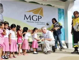  ??  ?? B2Gold Vice President for Operations Dale Craig along with Resident Manager Danilo Latuga are all smiles as they provide school bags to elementary students.