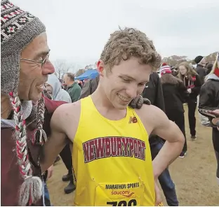  ?? STAFF PHOTO BY JOHN WILCOX ?? BIG POSTSEASON: Newburypor­t’s Sam Acquaviva gets a hug from his coach Don Hennigar after winning the Division 2 All-State cross country meet.