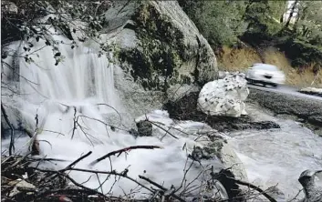  ?? LUIS SINCO Los Angeles Times ?? A STREAM along Highway 138 near Crestline on Thursday shows the effects of snowmelt in the San Bernardino Mountains. Residents who were snowbound now have to keep an eye out for f looding and rockslides.