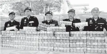  ??  ?? Paul (centre) showing the contraband cigarettes seized at a press conference at MPF Region 2 jetty base yesterday. Bernama photo