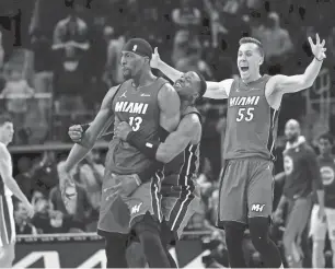  ?? RICK OSENTOSKI/USA TODAY SPORTS ?? Miami’s Bam Adebayo, left, celebrates with Terry Rozier and Duncan Robinson (55) after he hit a 3-pointer at the buzzer for a 104-101 win against the Pistons.