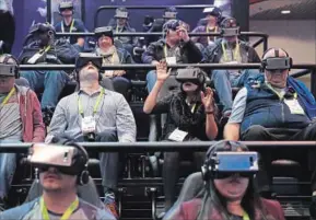  ?? THE ASSOCIATED PRESS ?? People look through Samsung Gear VR virtual reality goggles at the Samsung booth during the CES Internatio­nal trade show in Las Vegas in January.