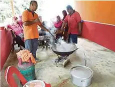  ??  ?? ROSMIZAN (kanan) melihat penduduk kampung bergotong-royong memasak makanan kenduri doa selamat selepas dilanda banjir kilat.