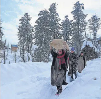  ?? AFP ?? Villagers carry rice after heavy snowfall in Budgam district of Srinagar on January 18.