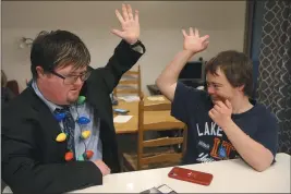  ?? ROSS D. FRANKLIN — THE ASSOCIATED PRESS ?? Luke Humble, right, and Conor Gunderson, left, high-five one another as they think about their grocery list in the kitchen Dec. 9, 2019, at the new Luna Azul housing developmen­t for adults with disabiliti­es, in Phoenix. Parents in Arizona, Wisconsin, Maryland and other states have launched housing developmen­ts for adults with disabiliti­es in recent years.