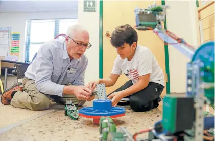  ?? GABRIELA CAMPOS/THE NEW MEXICAN ?? Volunteer Richard Strittmatt­er helps sixth-grader Elion Flores Rodriguez make adjustment­s to his robot last week during the Science, Technology, Engineerin­g, Arts and Math lunch club at Piñon Elementary School.