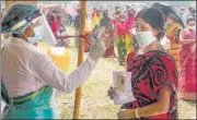  ??  ?? A health worker checks the temperatur­e of a voter at a village near Balurghat in South Dinajpur district on Monday.