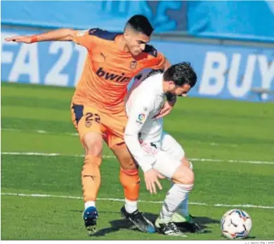  ?? J.J. GUILLÉN / EFE ?? El madridista Nacho protege la pelota ante Maxi Gómez.