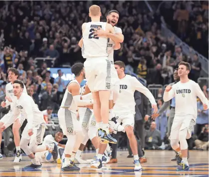  ?? MIKE DE SISTI / MILWAUKEE JOURNAL SENTINEL ?? Marquette guard Joseph Chartouny celebrates with forward Joey Hauser after the victory Saturday. Browse more photos from the game at jsonline.com/goldeneagl­es.