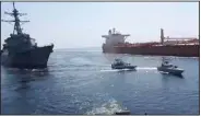  ?? (AP/Revolution­ary Guard) ?? Iran’s paramilita­ry Revolution­ary Guard speed boats (center) are seen Wednesday in front of a U.S warship (left) near a seized Vietnamese-flagged oil tanker in the Gulf of Oman.