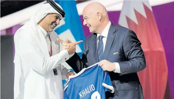  ?? AP ?? Sonrisas. El primer ministro qatarí, Khalid Bin Abdulaziz Al Thani, recibe una camiseta de regalo del presidente de la FIFA, Gianni Infantino.