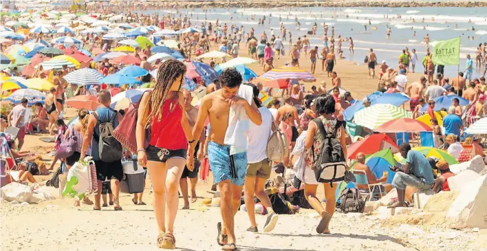  ?? FABIAN GASTIARENA ?? Playa Grande. Una pareja volviendo del mar, ayer, en otro día de clima excepciona­l, con el agua repleta de gente. Casi todos los días fueron así de esplendoro­sos.