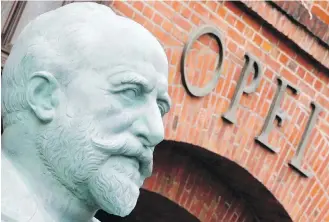  ?? MICHAEL PROBST, THE ASSOCIATED PRESS ?? A sculpture of founder Adam Opel stands in front of the old main entrance of Opel Auto in Ruesselshe­im, Germany.