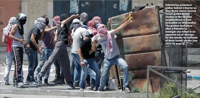  ?? AFP
Photo: ?? Palestinia­n protesters gather behind a barrier as they throw stones toward Israeli police during clashes in the Shuafat neighborho­od in East Jerusalem on Wednesday. The protest took place after a Palestinia­n teenager was killed in an apparent act of...