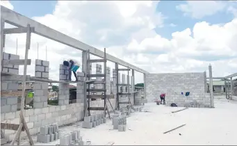  ?? ?? Workers laying blocks for the walls of the administra­tive building