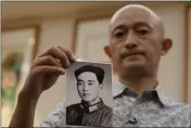  ?? NG HAN GUAN — THE ASSOCIATED PRESS ?? Zhang Hai holds up a photo of his father taken in his youth during an interview in Shenzhen in southern China’s Guangdong province on Friday. Zhang is demanding to meet a visiting World Health Organizati­on expert team.