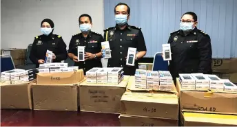  ??  ?? Kelyn (second right) and his officers show the seized counterfei­t calculator­s.