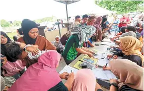  ?? ?? Seeking help: Flood victims registerin­g with the Welfare department at al-munir Mosque. — Bernama