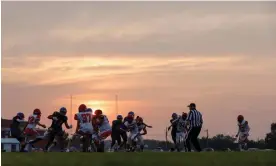  ?? Jonathan Ernst/Reuters ?? Players compete in a high school football game in South Dakota. Friday night games have been held this summer later in the evening and teams are practising at dawn. Photograph: