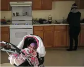  ?? Jerry Lara / Staff photograph­er ?? Nine-month-old Lariyah Harris waits in a stroller while her mother, Kristal, uses the gas stove for heat.