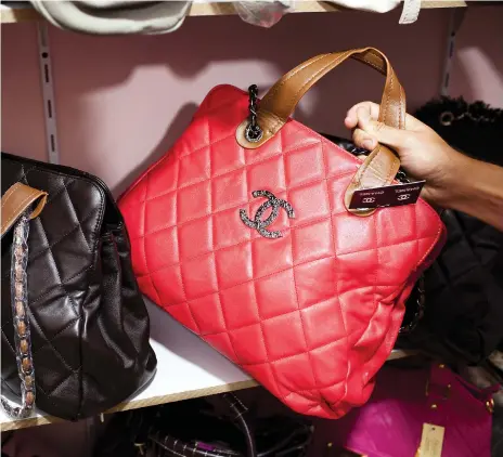  ?? Andrew Henderson / The National ?? Fake Louis Vuitton and Chanel handbags on display in a secret room at a Dubai market