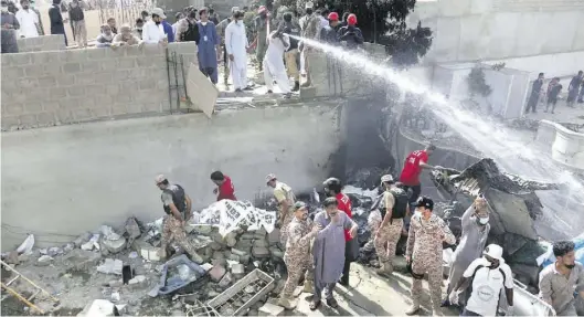  ?? AP-BILD: KHAN ?? Trümmerfel­d: Soldaten und Freiwillig­e an der Absturzste­lle in der pakistanis­chen Stadt Karatschi