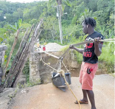  ?? ?? Residents use this bucket pulley system to move goods across the Hector’s River in Trelawny.