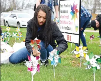  ?? TIMES photograph by Annette Beard ?? Dayton McLeroy, eighth grade, was one of several students placing pinwheels on the lawn in front of the Pea Ridge Police station Monday for Child Abuse Prevention Month.