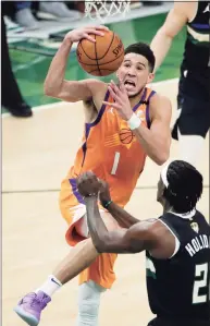  ?? Aaron Gash / Associated Press ?? Phoenix Suns guard Devin Booker (1) drives to the basket against Milwaukee Bucks guard Jrue Holiday during the first half of Game 6 of the NBA Finals on Tuesday.