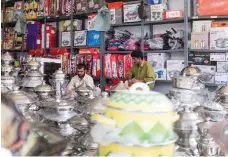  ?? Reem Mohammed / The National ?? Clockwise from top, the fire that gutted the Friday Market in Masafi on May 30, 2015; a shop that sold carpets before it was destroyed by the blaze and has had to turn to selling kitchen items; and a fruit and vegetable shop in the market