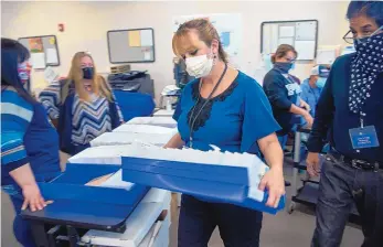  ?? EDDIE MOORE/JOURNAL ?? Presiding Judge Andrea Campos, center, and her staff process and scan absentee ballots in the Rio Arriba County Clerk’s office in Tierra Amarilla. The county has received more than 3,000 absentee ballots so far.