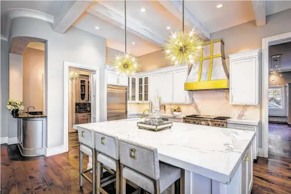  ?? Jeff Djayasaput­ra / Bayou City 360 ?? The kitchen refresh included new paint and lighting and replacing black granite counters with Neolith, a durable man-made surface, in a pattern that looks like Italian Calacatta marble.