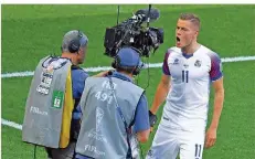  ?? FOTO: YUGUO/XINHUA/DPA ?? Bundesliga-Profi Alfred Finnbogaso­n (rechts) läuft auf die Kamera zu. Die Welt soll sehen, wer den Ausgleich gegen Argentinie­n erzielt hat.