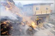  ?? AP PHOTO BY DAVID CRANE ?? Firefighte­rs put out flames near a home along Kagel Canyon road at the Creek fire, Tuesday in Lake View Terrace area of Los Angeles . Raked by ferocious Santa Ana winds, explosive wildfires northwest of Los Angeles and in the city's foothills burned a psychiatri­c hospital and scores of other structures Tuesday and forced the evacuation of tens of thousands of people.