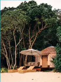  ??  ?? From left: The alluring turquoise waters off Awei Pila; view of a villa on the beach cocooned in nature; a school of parrot fish surrounded by corals