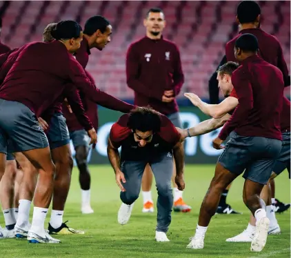  ?? REUTERS ?? Running the gauntlet: Salah looks relaxed as he jokes with Liverpool team-mates in training