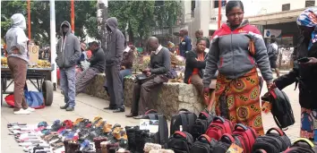  ?? - (Picture by Memory Mangombe) ?? An unidentifi­ed woman takes advantage of the cold weather to sell winter wear in streets of Harare.