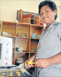  ??  ?? Biscuit bonanza: Namoori Teikake makes ready to pop another batch in the oven at the St Vincent de Paul’s shop last Tuesday.