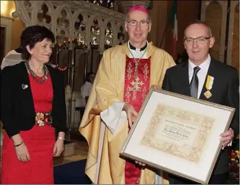  ??  ?? Ger Lawlor receives his Pro Ecclesia et Pontifice papal award from Bishop Denis Brennan at the Festival Mass on Sunday. Also in the picture is Ger’s wife Laura.