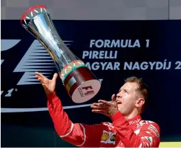  ?? — AP ?? Ferrari’s Sebastian Vettel celebrates with his trophy after winning the Hungarian Grand Prix in Budapest on Sunday.