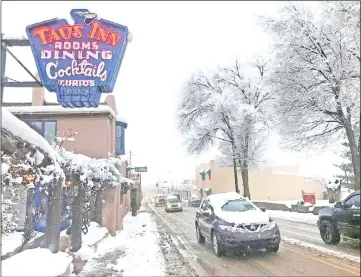  ??  ?? Traffic moved through the town centre after a major winter storm dropped around 8cm of snow in Taos, New Mexico. — Reuters photo