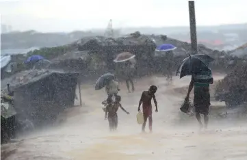  ??  ?? File photo shows a Rohingya refugee child carrrying water during rain in a refugee camp at Kutupalong refugee camp in Bangladesh’s Ukhia district. – AFP photo