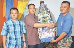  ??  ?? Rafie (centre) presents a prize to the representa­tive of a high performanc­e team while Abdul Mutalif looks on.